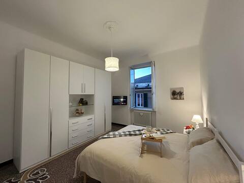 Camera da letto con ampio armadio bianco, letto matrimoniale e finestra
